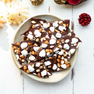 pieces of chocolate bark with marshmallows and almonds on a plate.