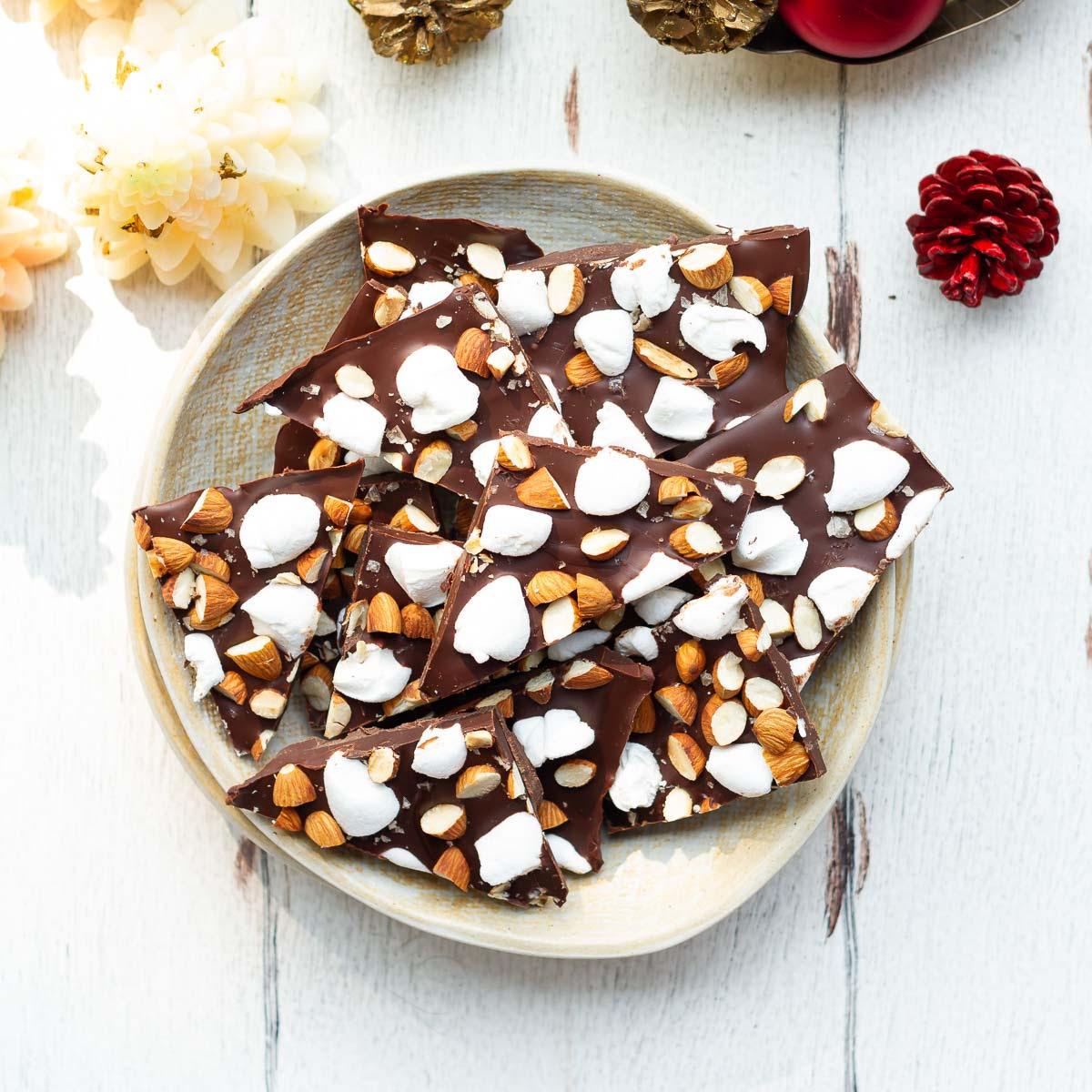 pieces of chocolate bark with marshmallows and almonds on a plate.