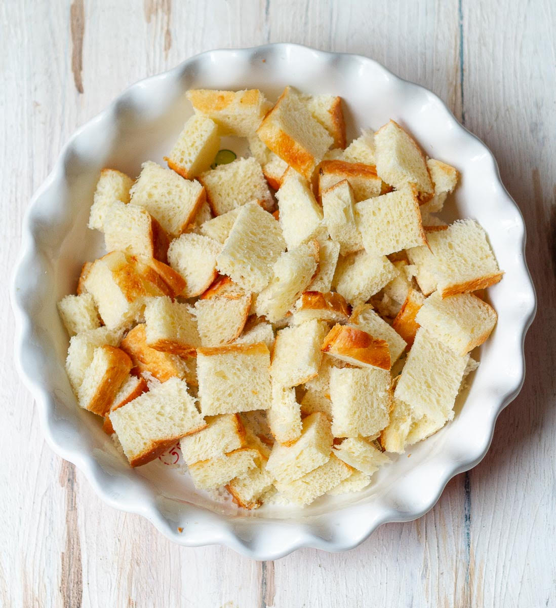 Cubed bread slices in a baking dish.