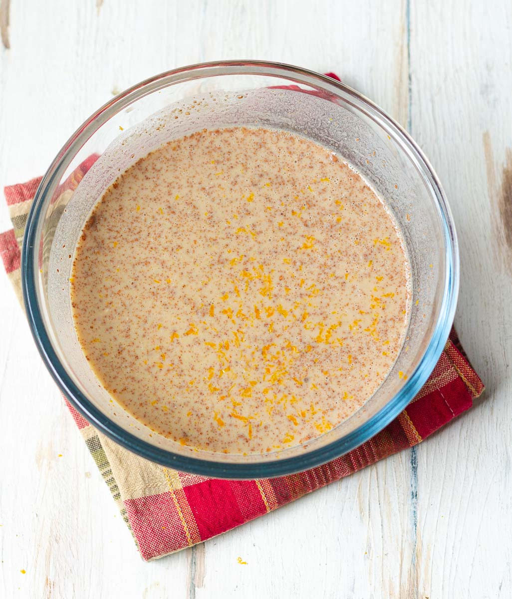 Mixture of milk, eggs, brown sugar, cinnamon powder, salt and orange zest in a bowl.