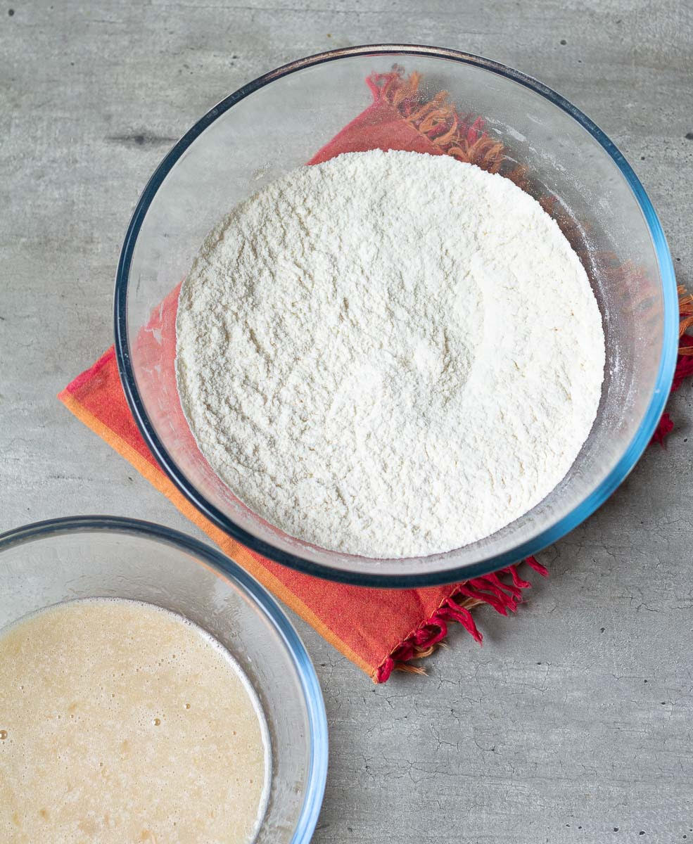 Wet and dry ingredients for muffins in mixing bowls.