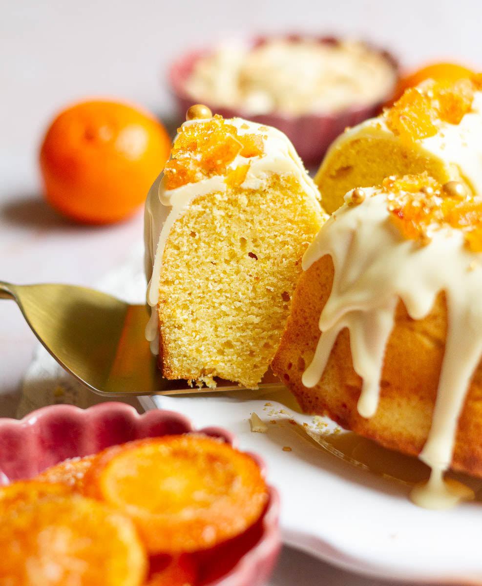 A slice of orange cake on a cake server.