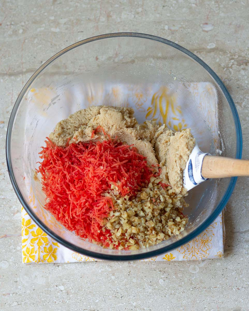 grated carrots and chopped walnuts getting folded in the cookie dough.
