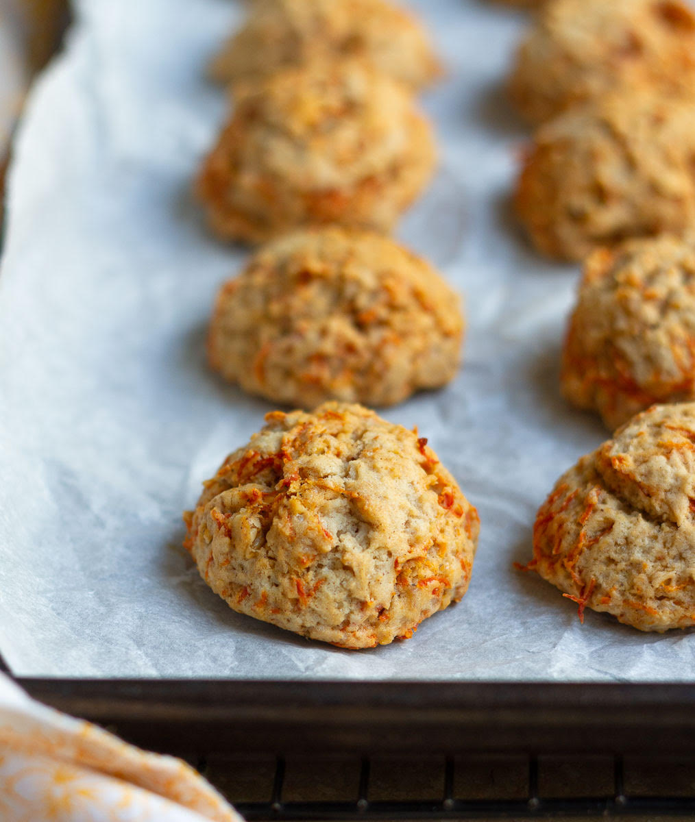 carrot cake cookies on a parchment lined baking tray.