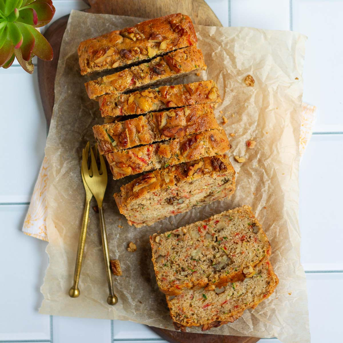 Carrot Zucchini Bread on parchment paper lined board with 2 forks.