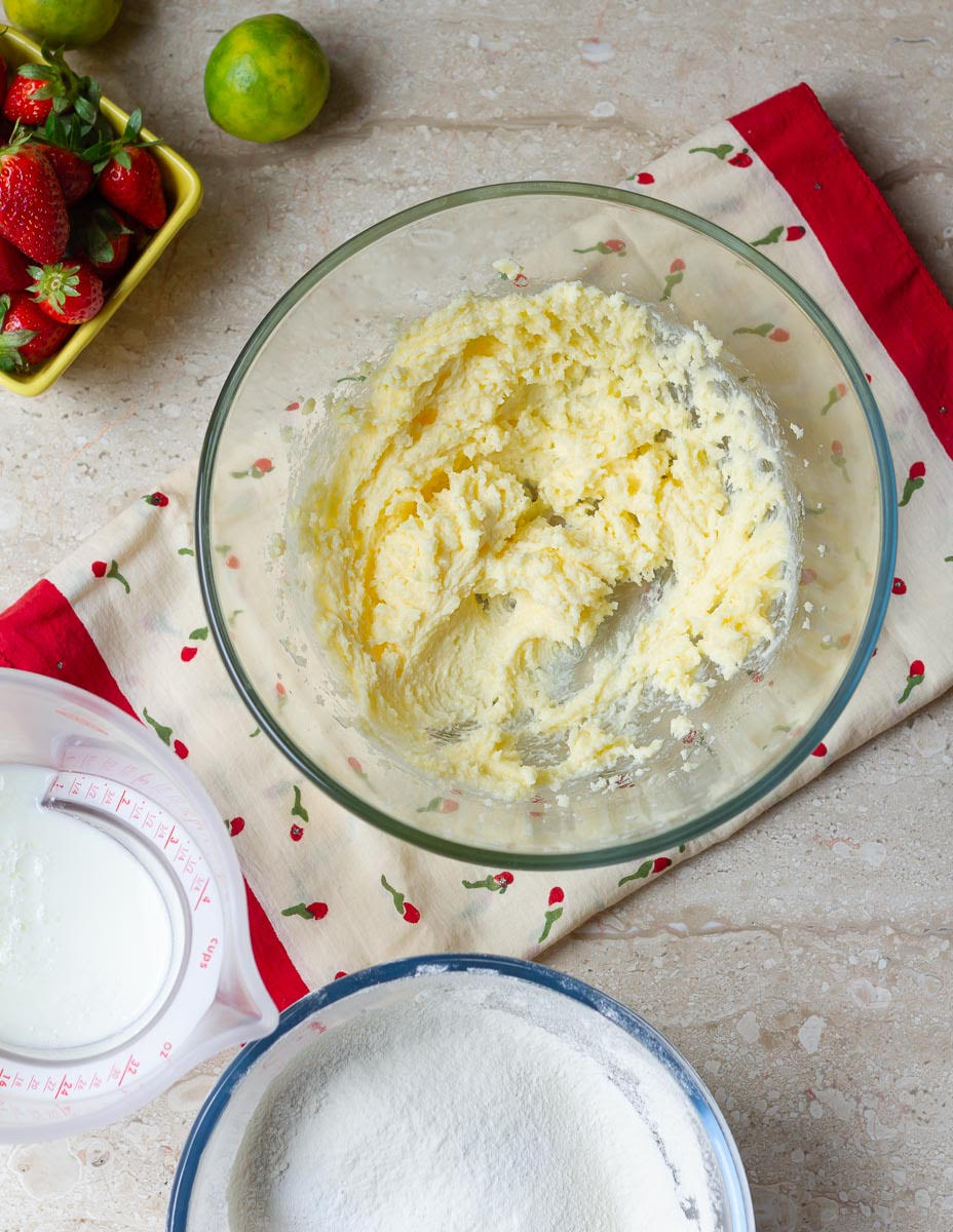 creamed butter and sugar in a bowl with buttermilk and dry ingredients on the side.