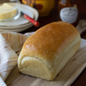 A loaf of sandwich bread on a wooden board.