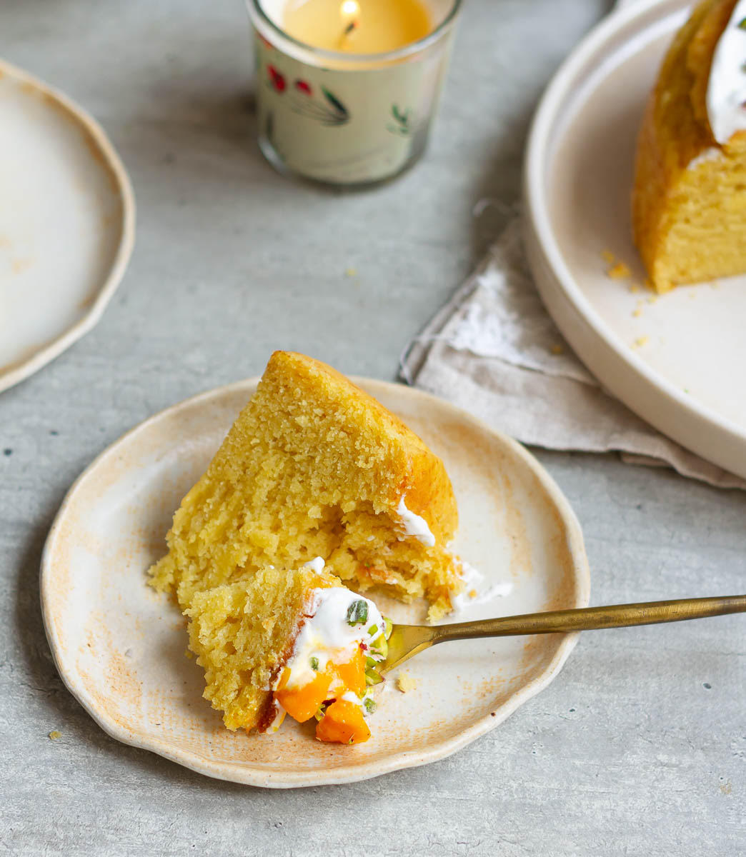 A bite of cake from a slice on a small plate.