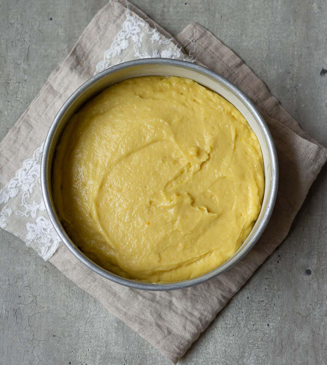 Cake batter in a round cake tin.