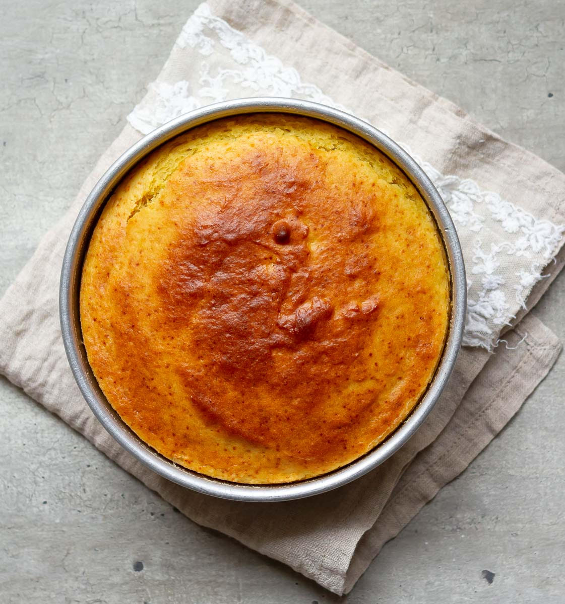 Baked mango cake in a cake tin.