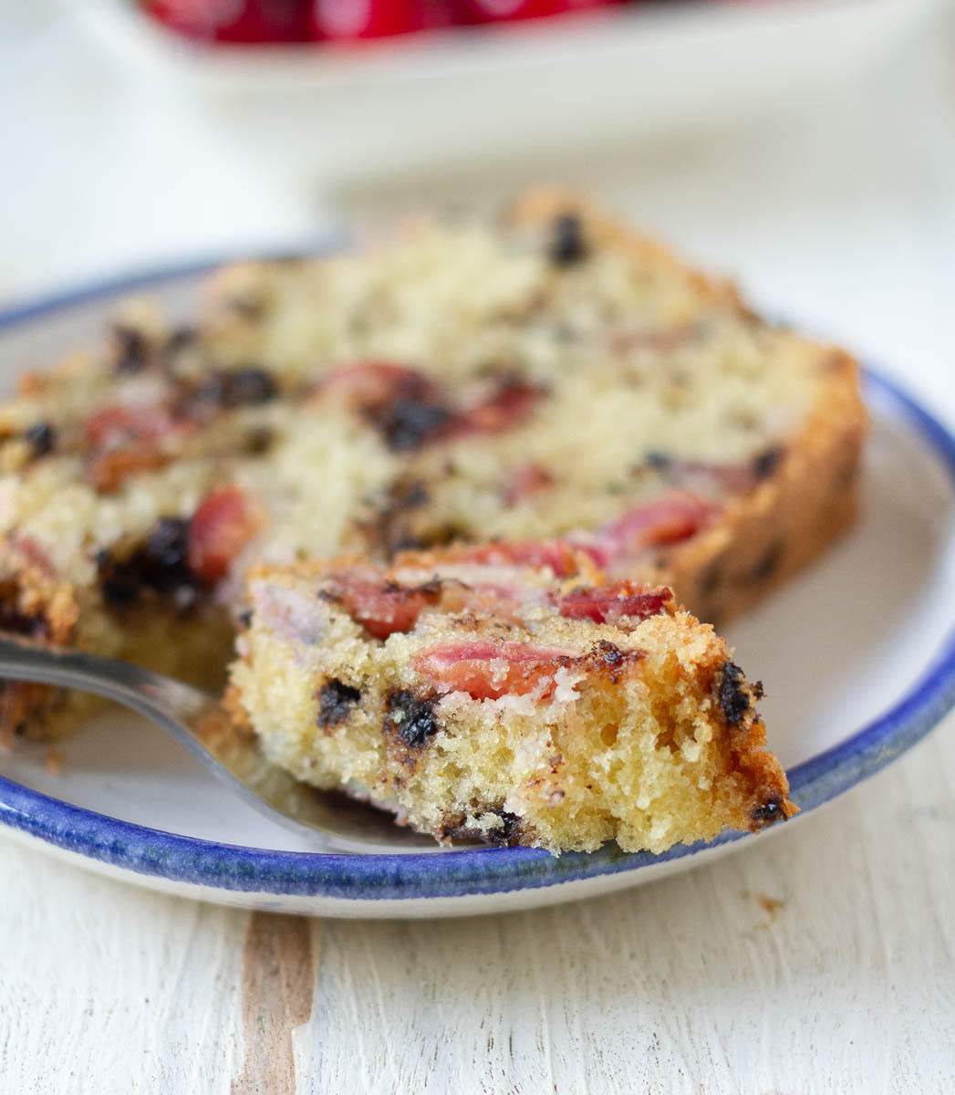 A bite of cake from a slice on a small plate.