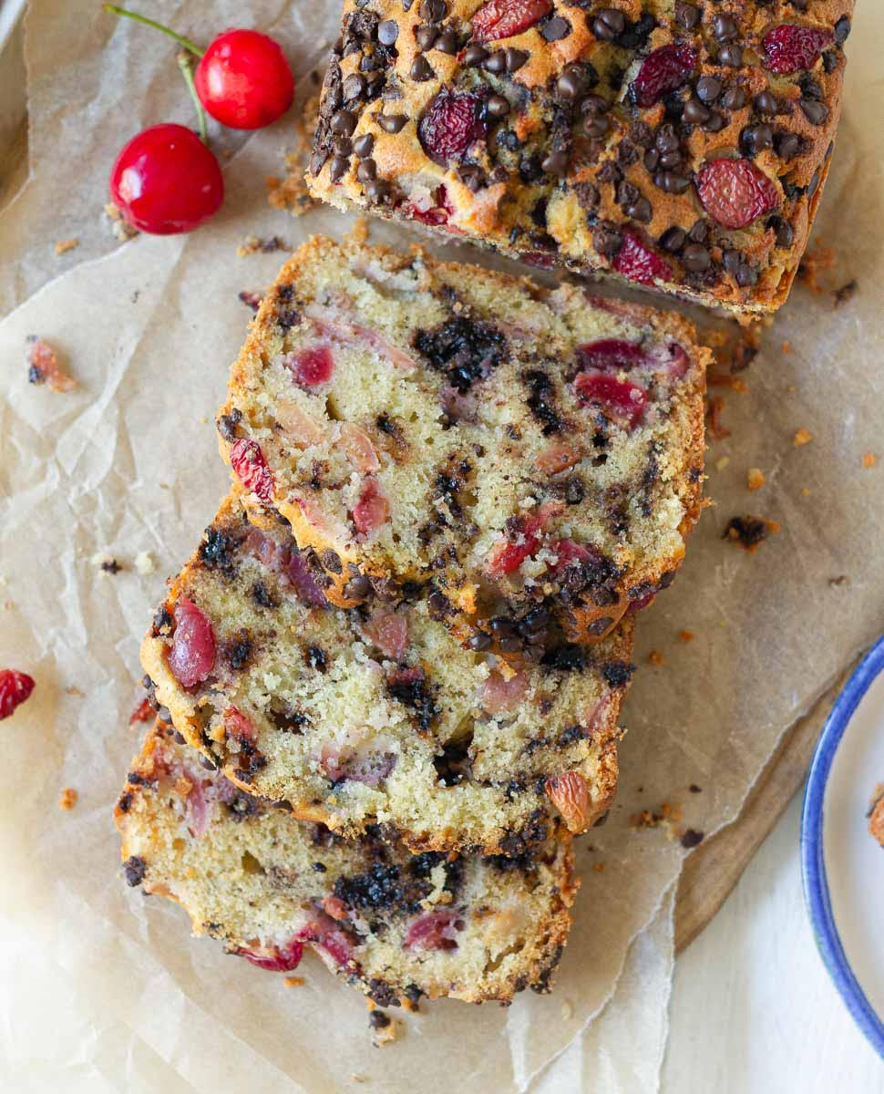 Sliced Cherry Chocolate Chip Cake on parchment paper.