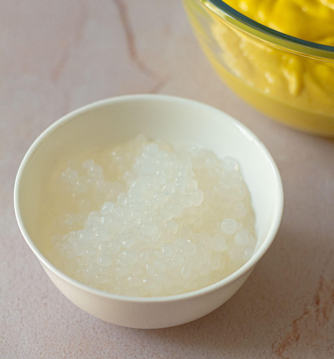 Drained cooked sago in a small white bowl.