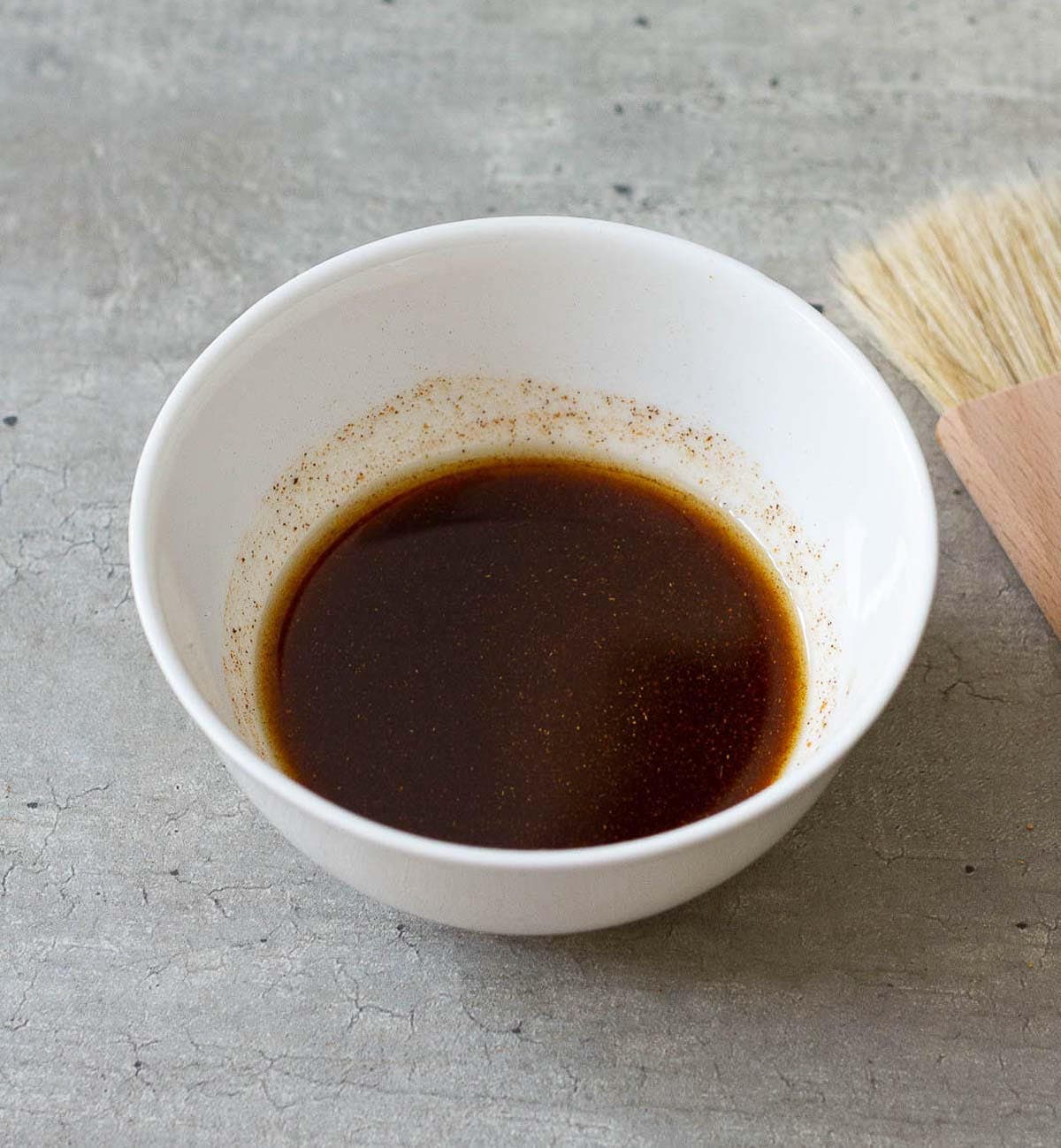 olive oil, spices and seasonings mixed in a small white bowl.