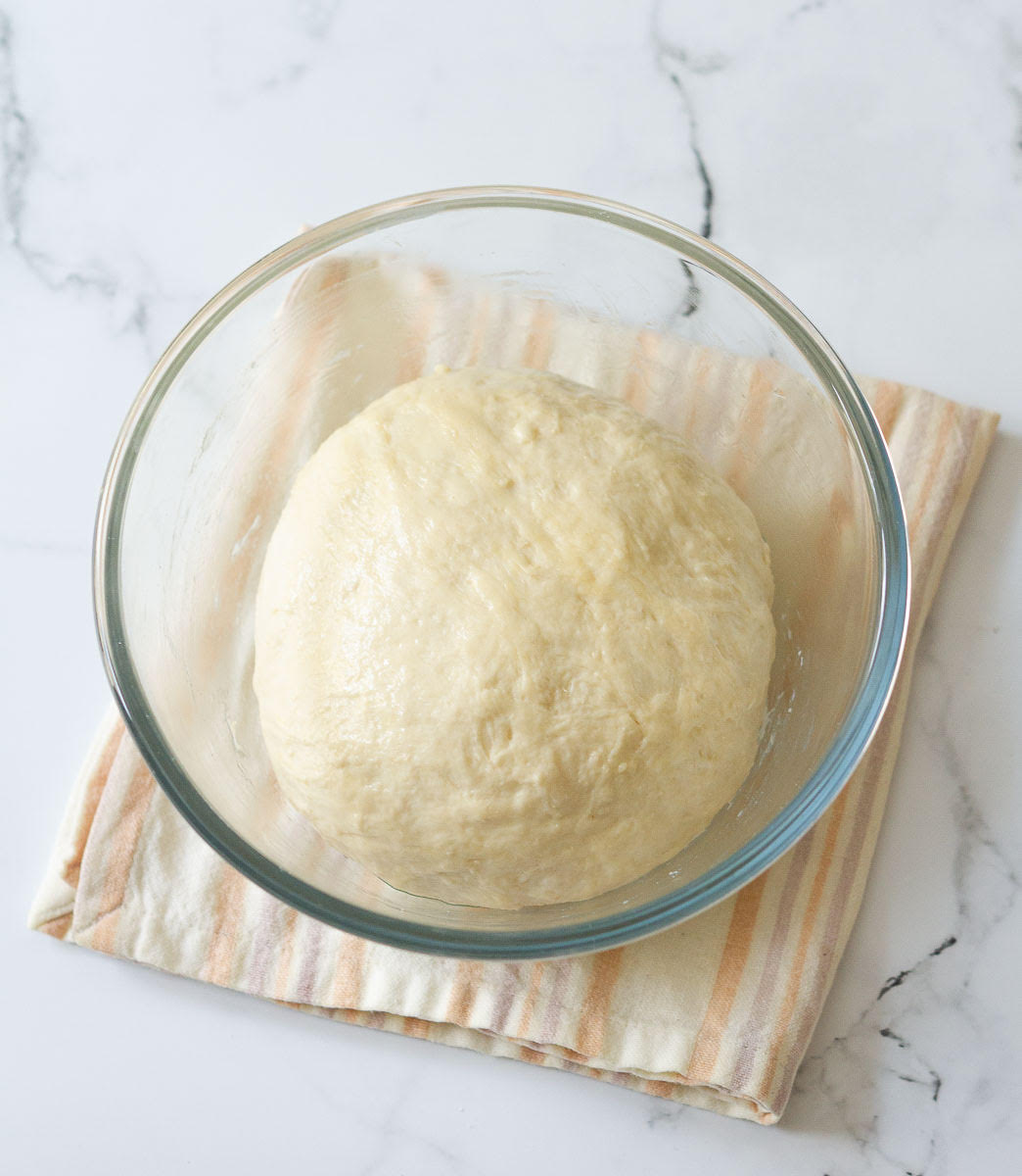 Bread dough in a glass mixing bowl.