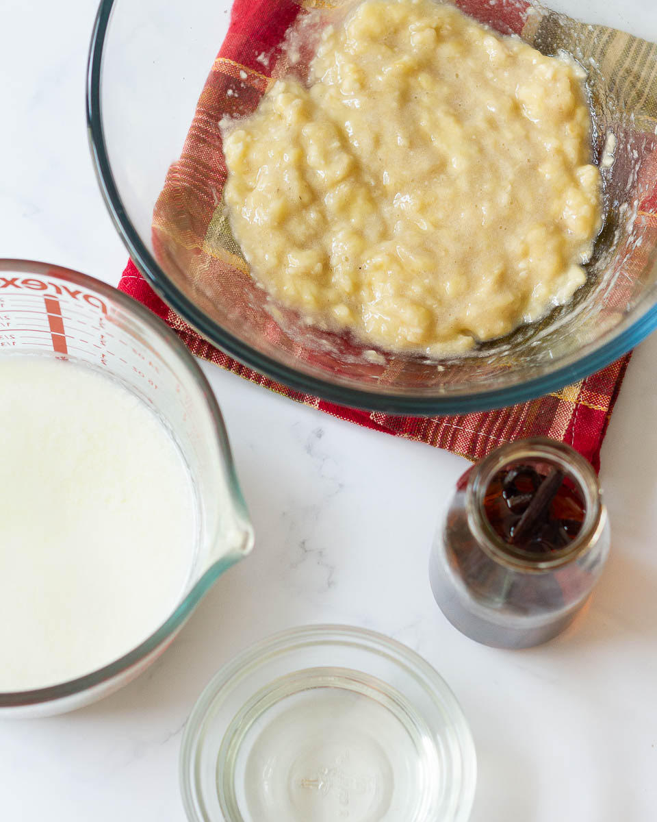 Mashed bananas, milk, vanilla extract, and oil in separate bowls.
