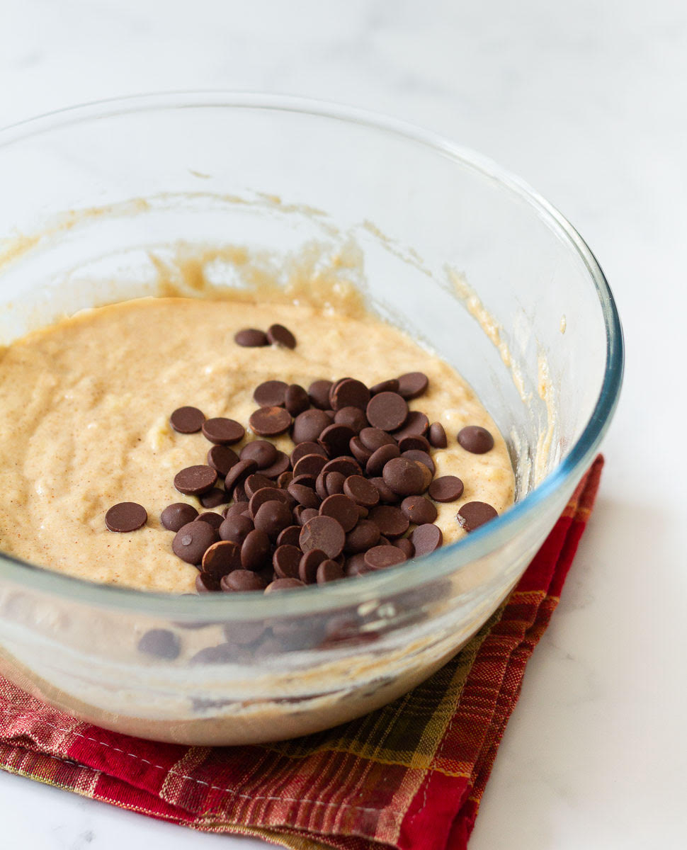 Chocolate chips on top of cake batter in a mixing bowl.