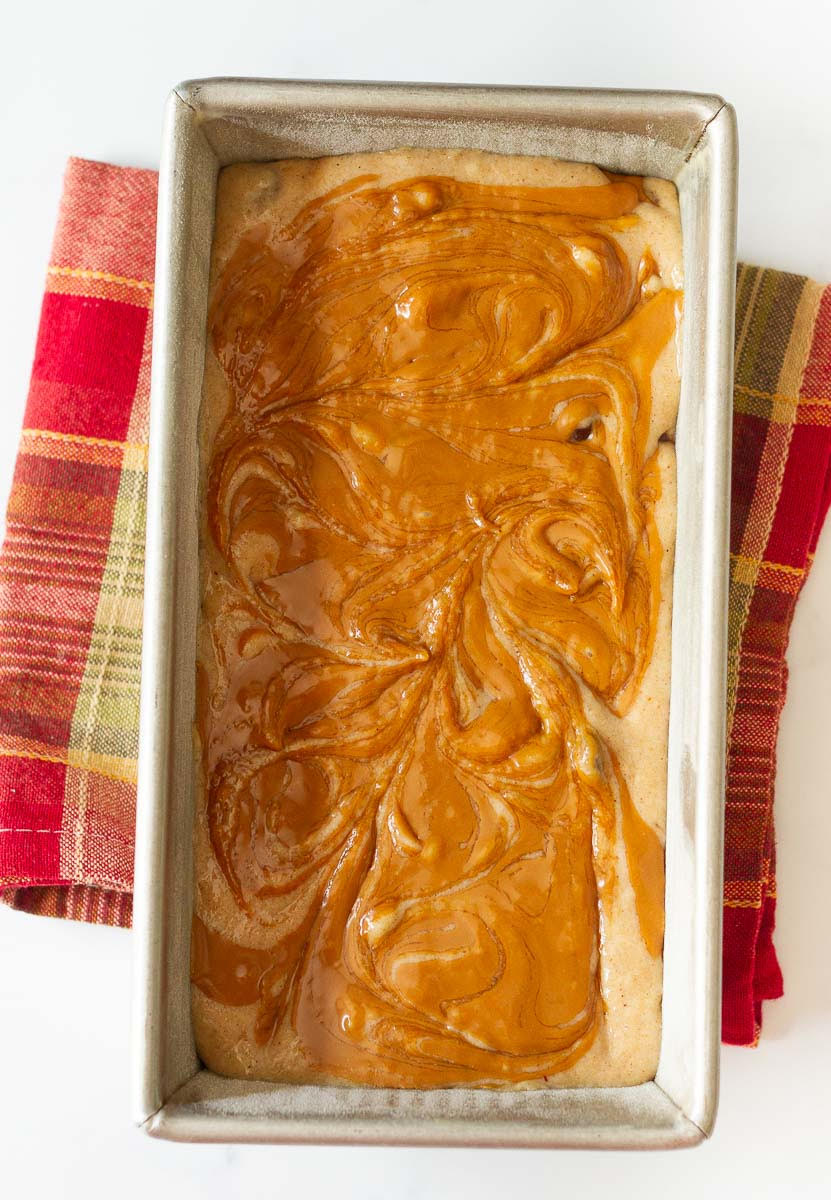 Banana bread batter with Biscoff on top in a loaf tin.
