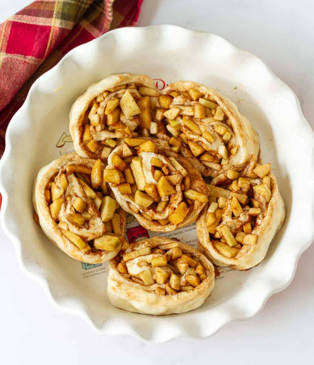 Apple rolls in a round baking pan for 2nd proof.
