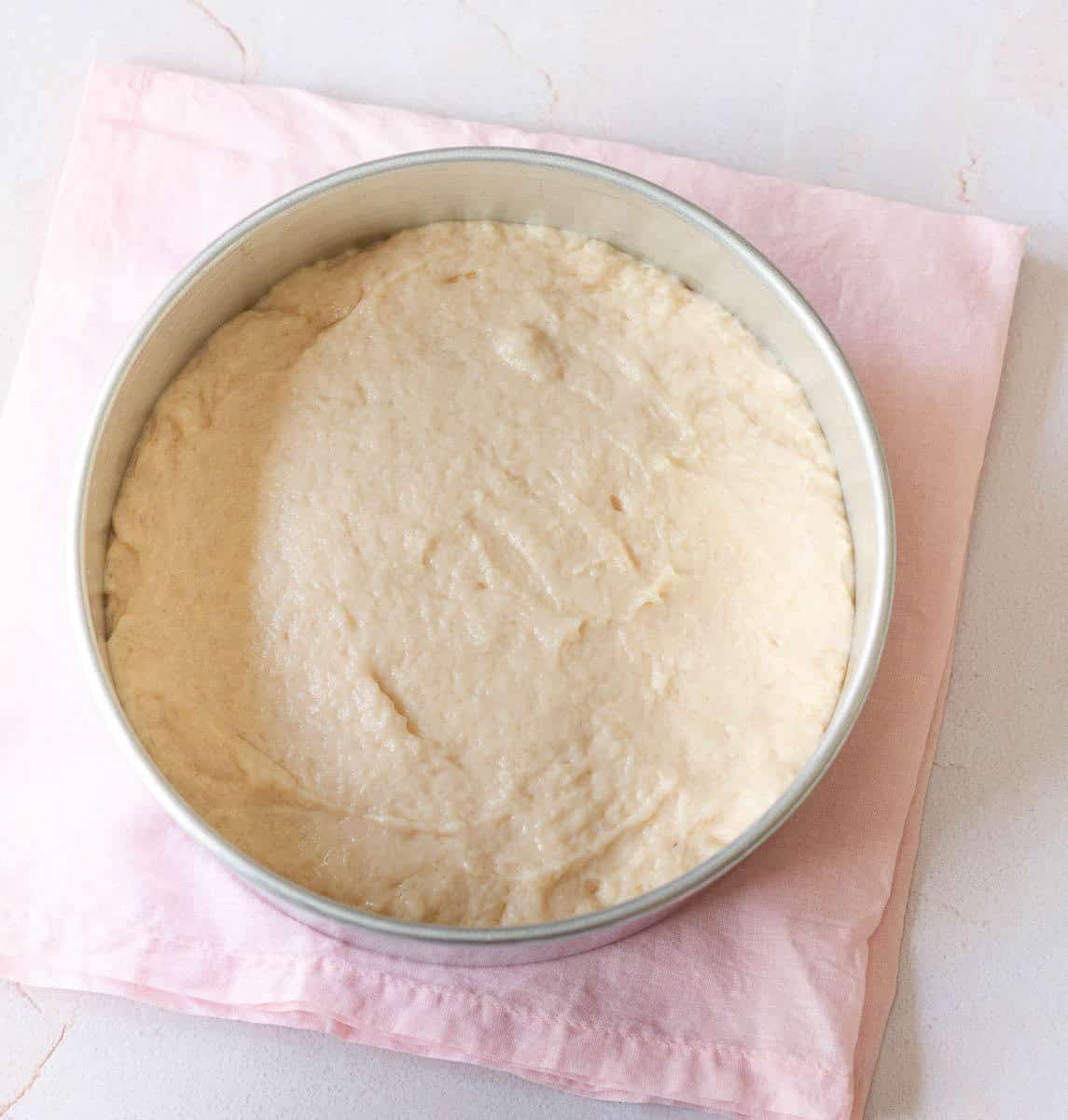 cake batter in a round cake tin.