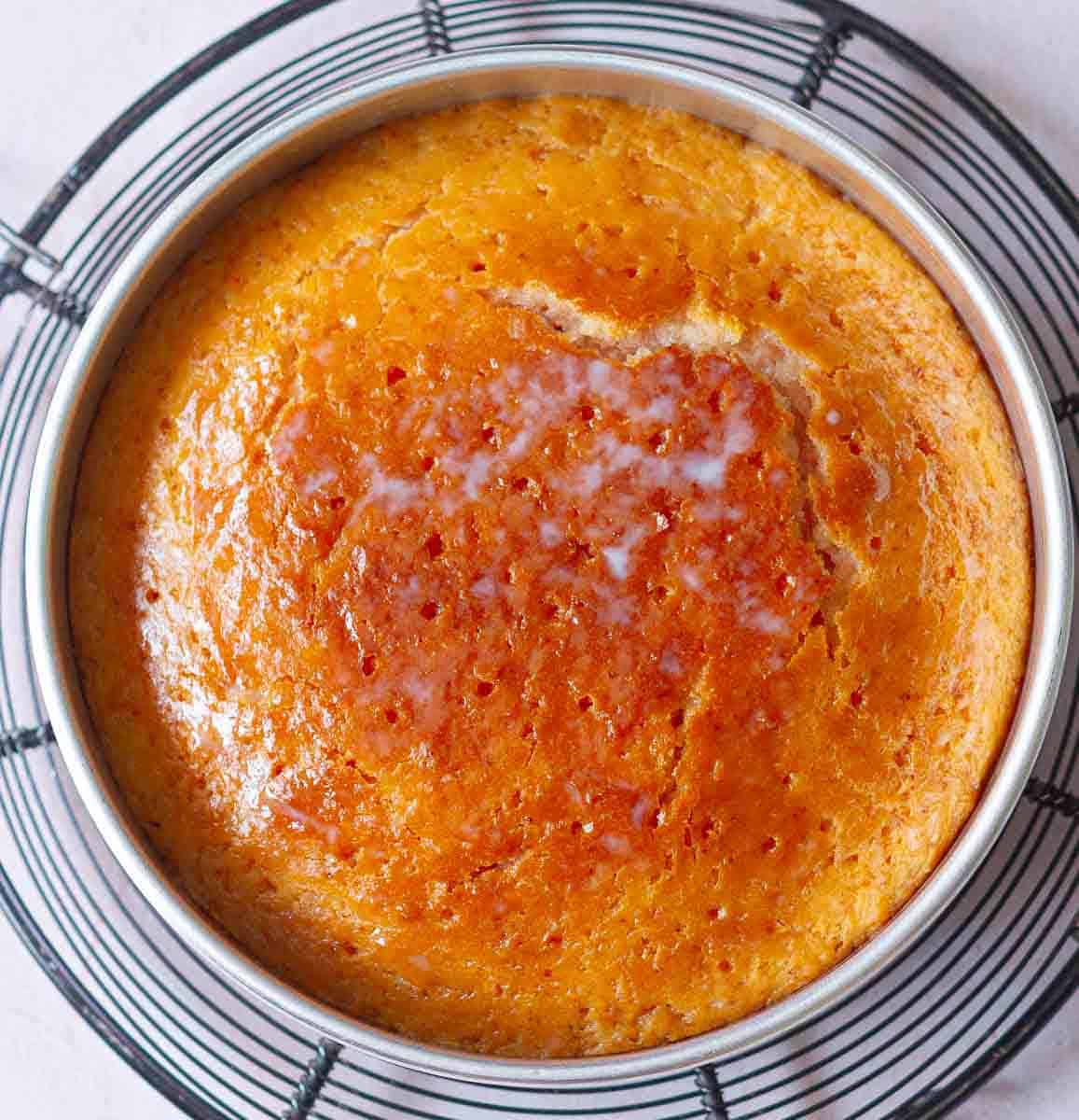 Cake soaked in rose syrup in a cake tin.