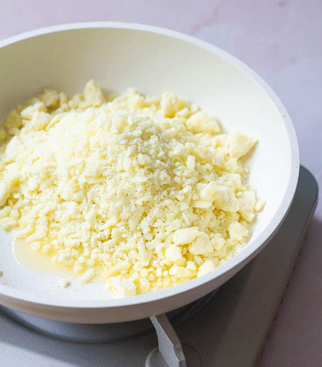 grated khoya with ghee in a pan