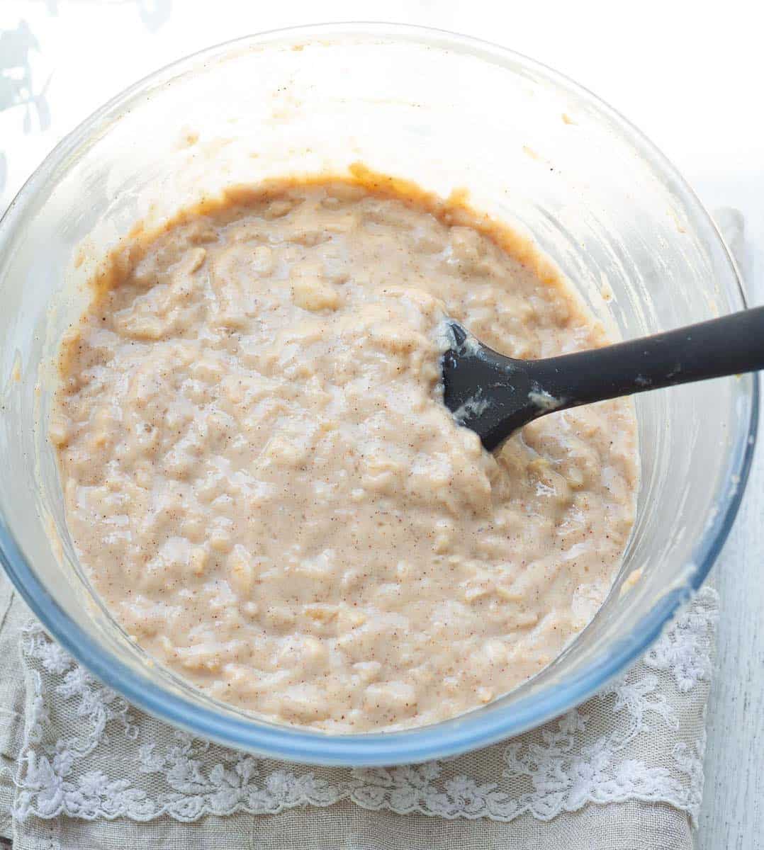 Batter for the apple donuts in a glass bowl.