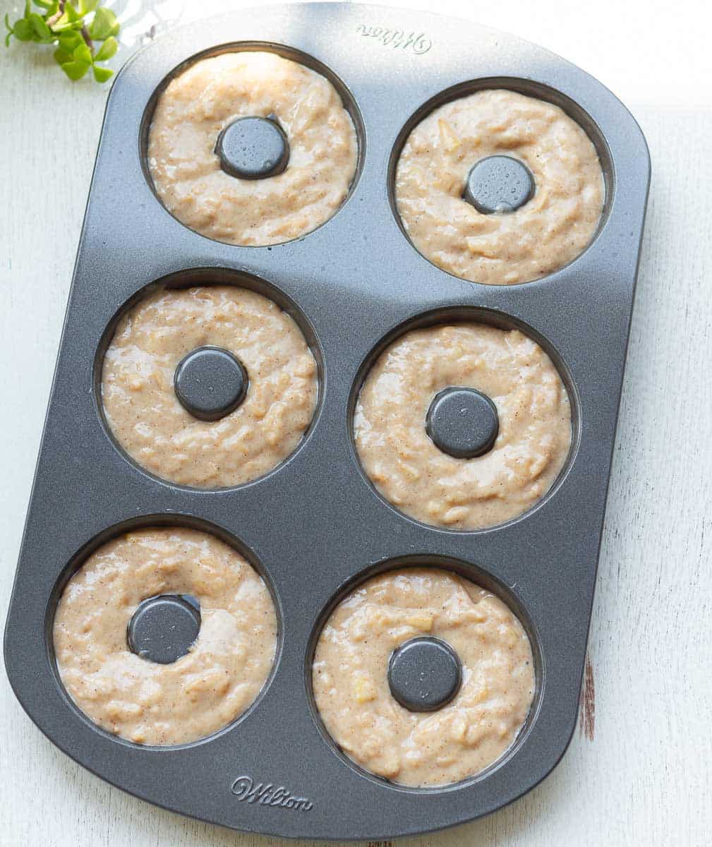 Donut batter in a metal donut pan.