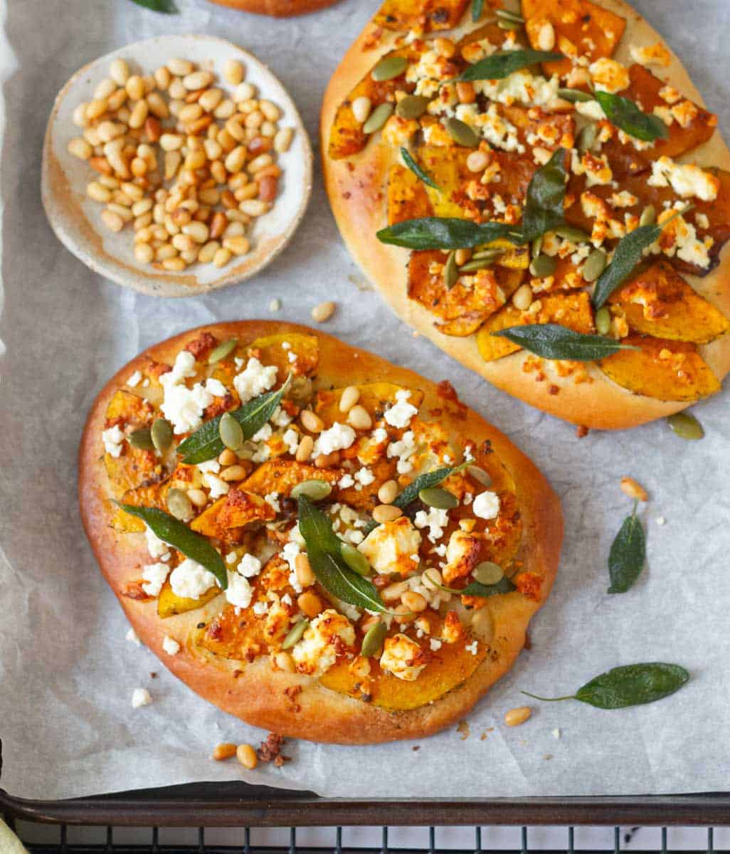 Baked butternut squash flatbread on parchment paper.