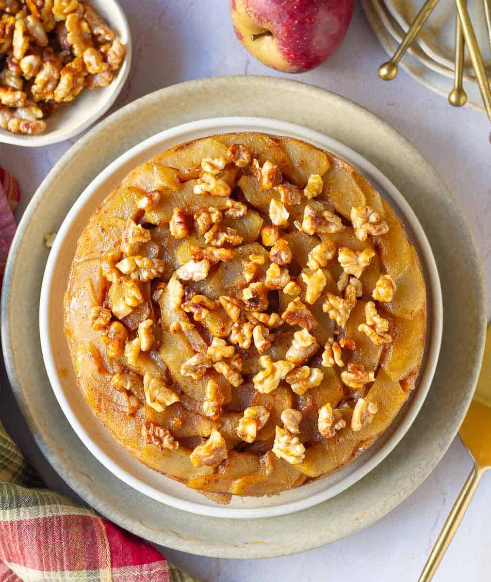 Upside Down Apple Cake on a platter with ingredients around.