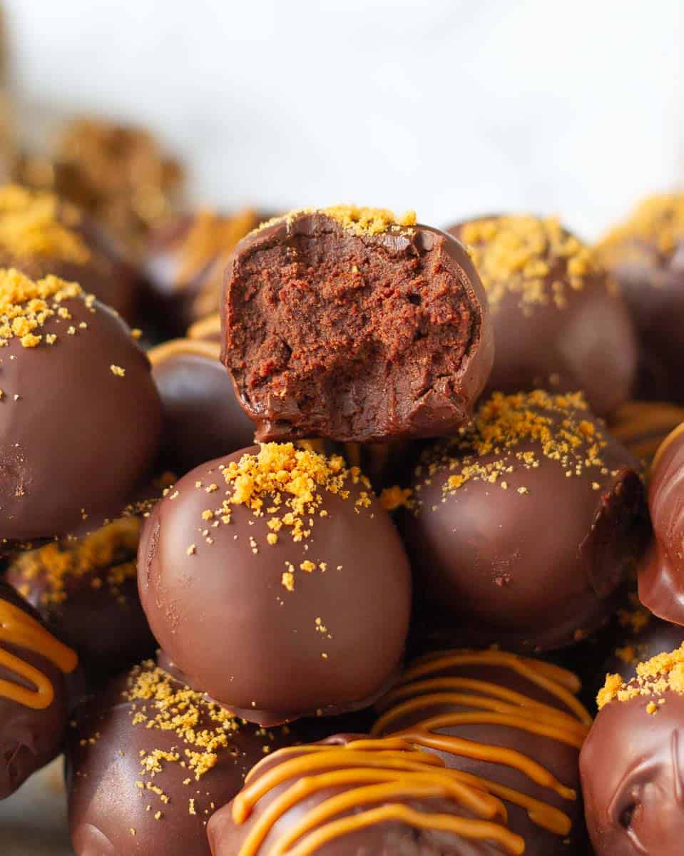 Half a truffle on top of truffles to show the fudgy texture.