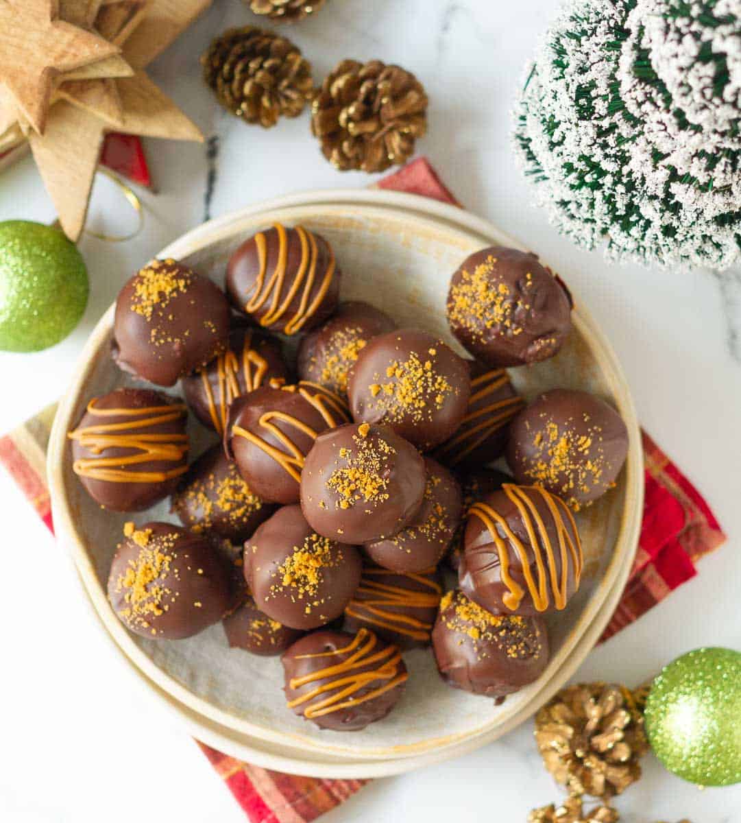 Biscoff truffles drizzled with Biscoff on a plate.