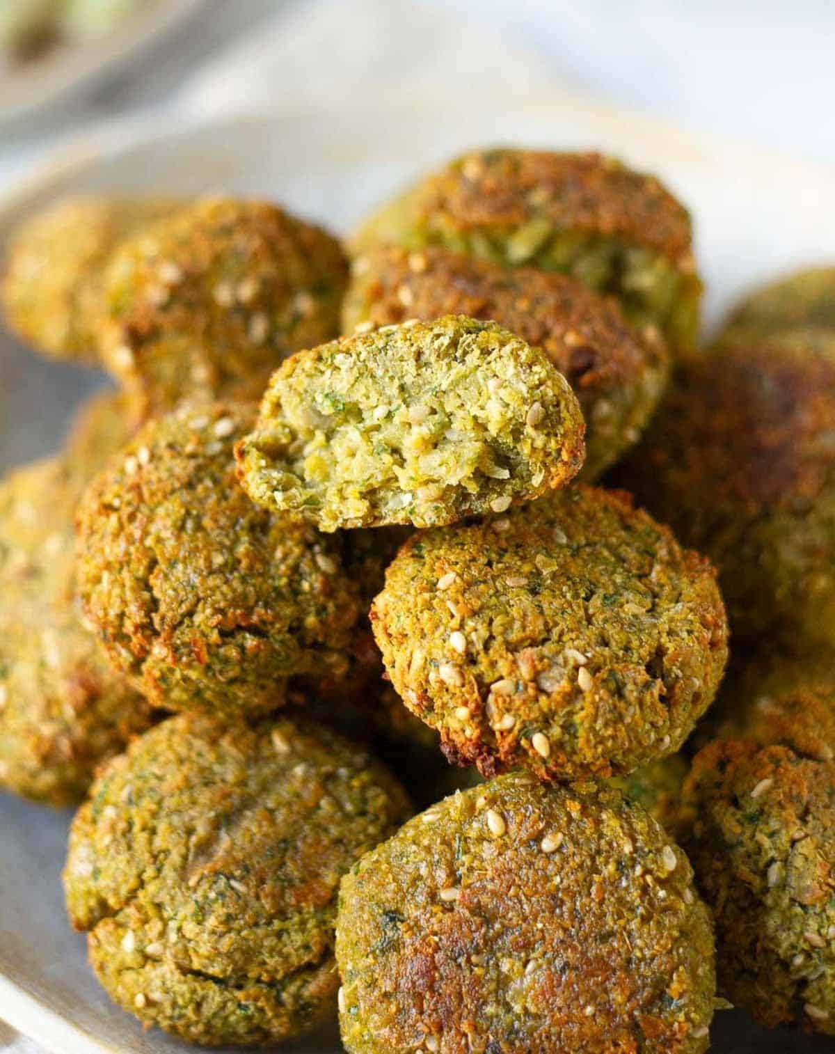 A stack of falafels with one cut in half to show the texture.