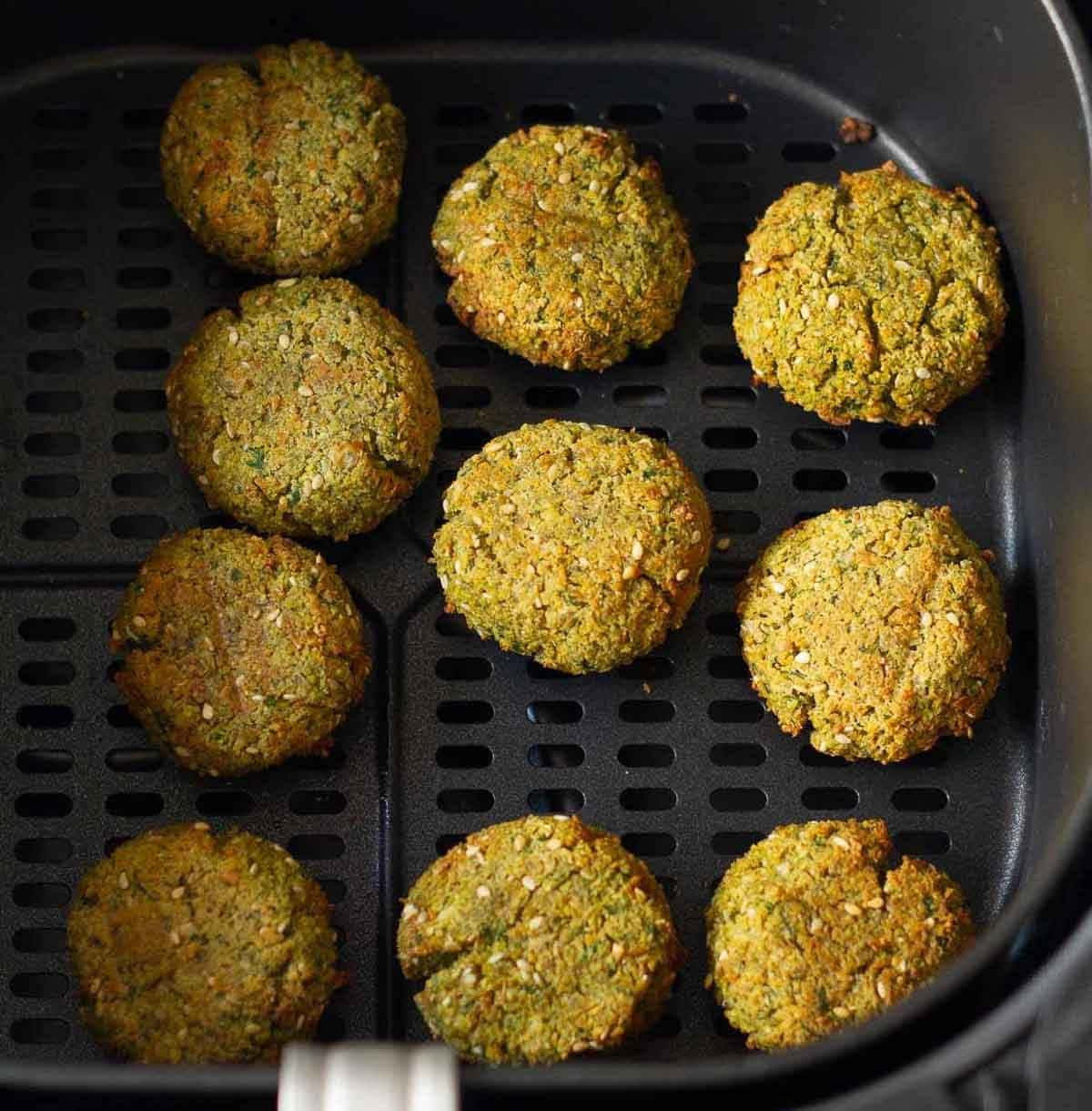 cooked falafels in a airfryer basket.