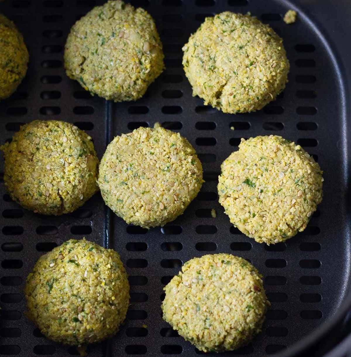 Falafel patties in air fryer basket.