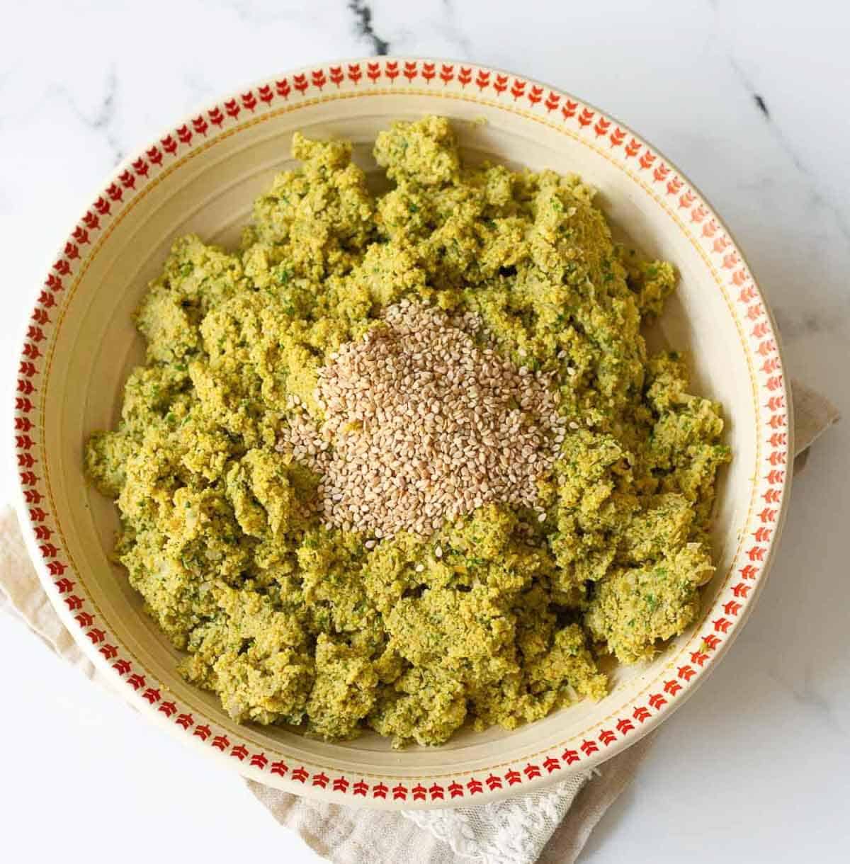 sesame seeds on top of falafel mixture.