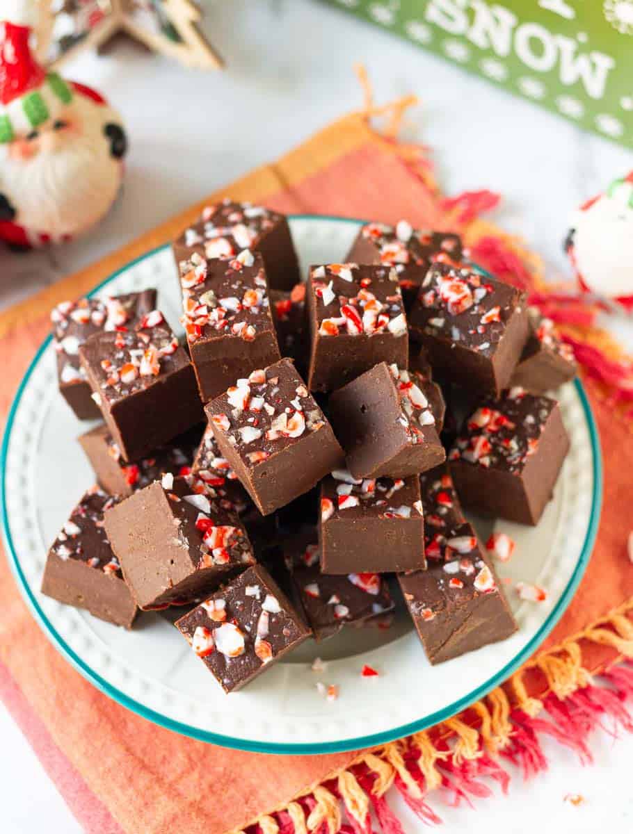 Chocolate fudge with crushed candy cane pieces on a plate.