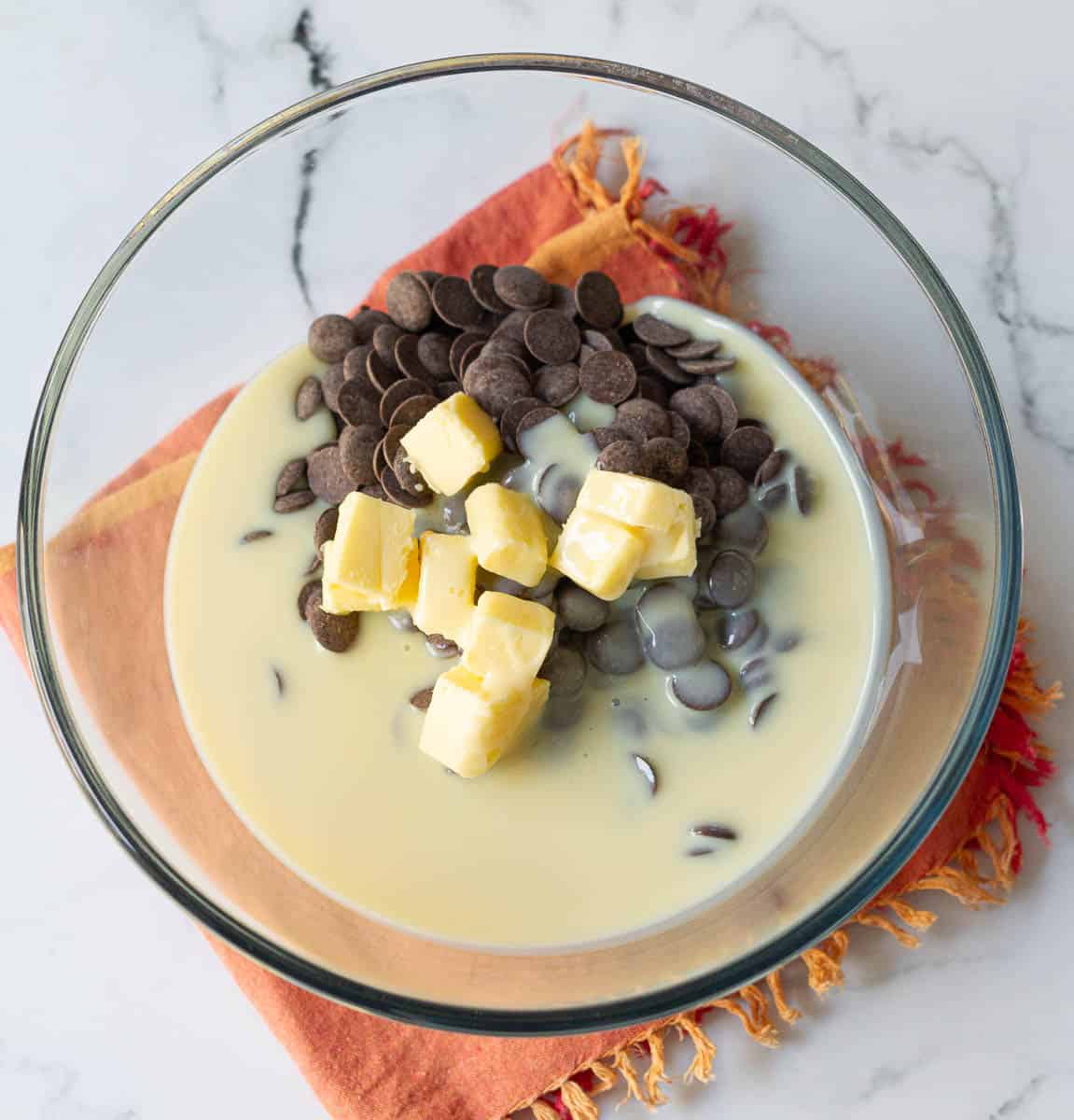 Butter, condensed milk, and chocolate in a large bowl.