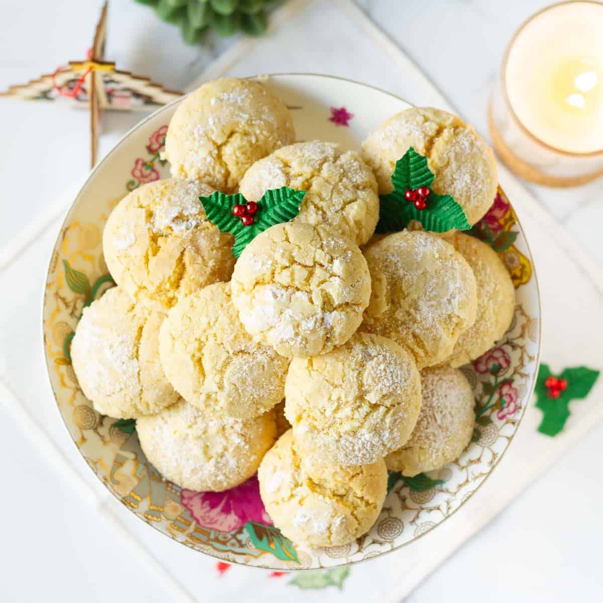 lemon crinkle cookies on a platter with Christmas decorations around.