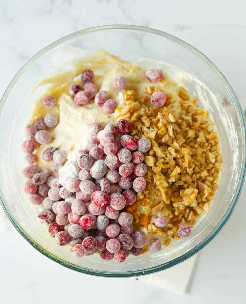 Fold in frozen cranberries, chopped walnuts, orange zest