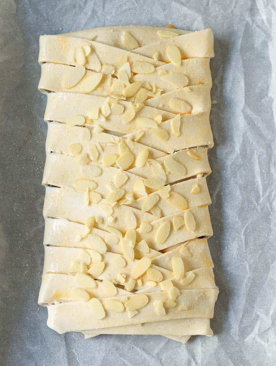 Pastry braid brushed with egg and topped with almond flakes and sugar.