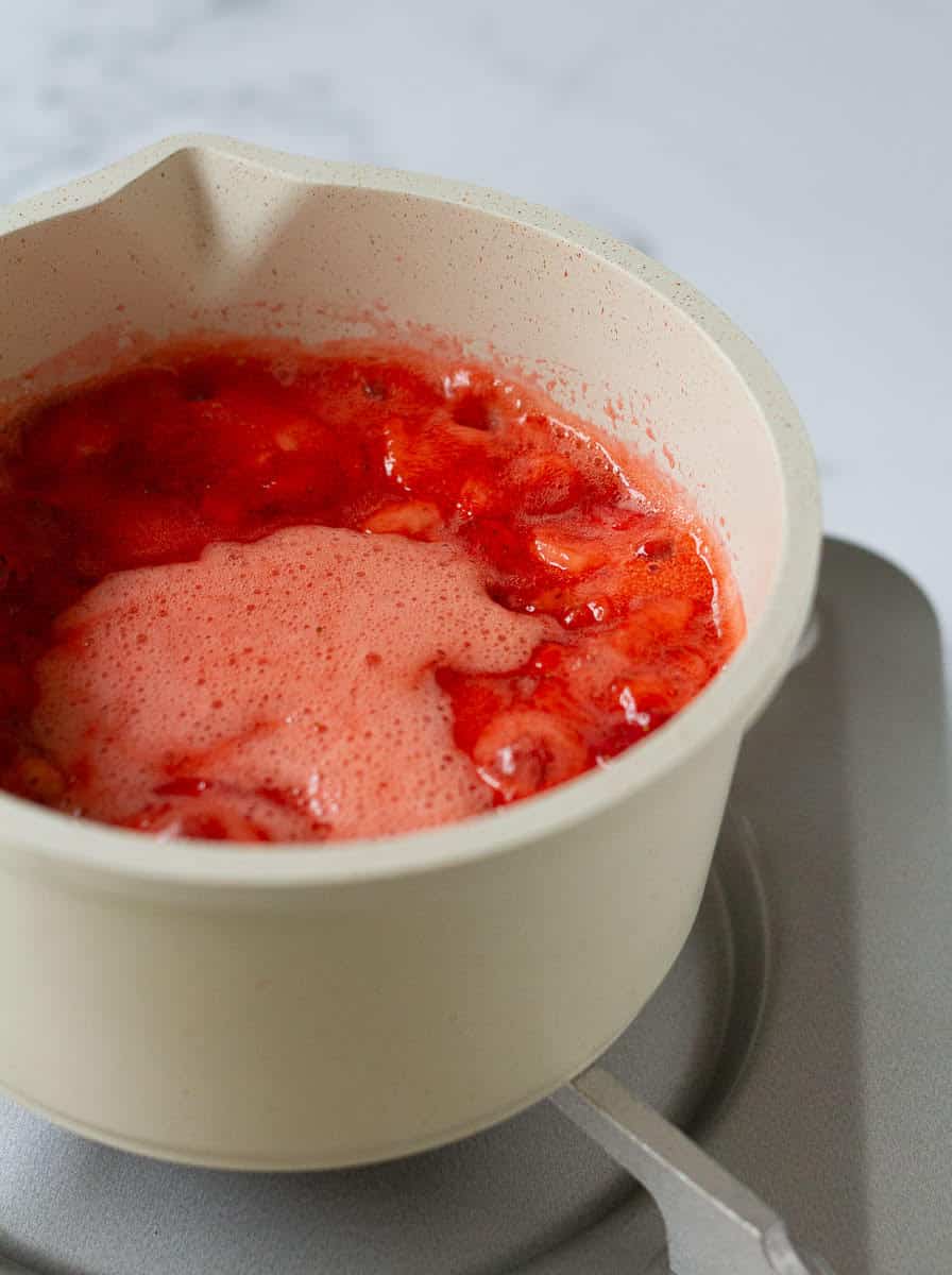 strawberries getting cooked in a saucepan.