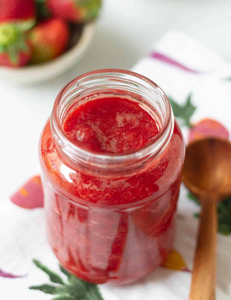 Strawberry syrup in a glass jar.