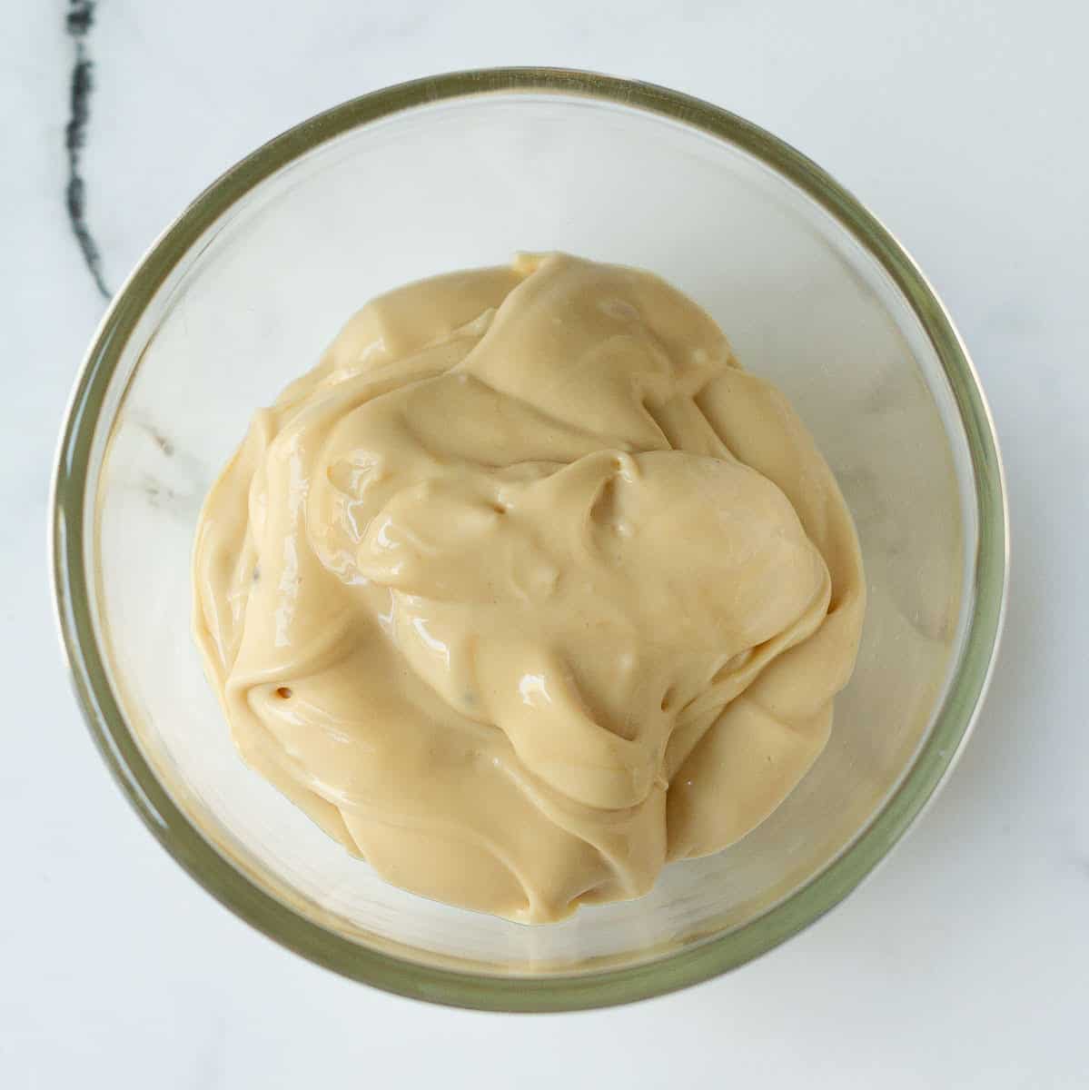 Coffee cream cheese frosting in a small glass bowl