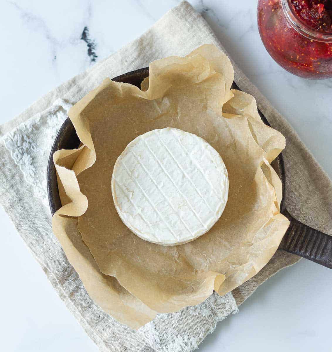 Brie on parchment lined cast iron skillet