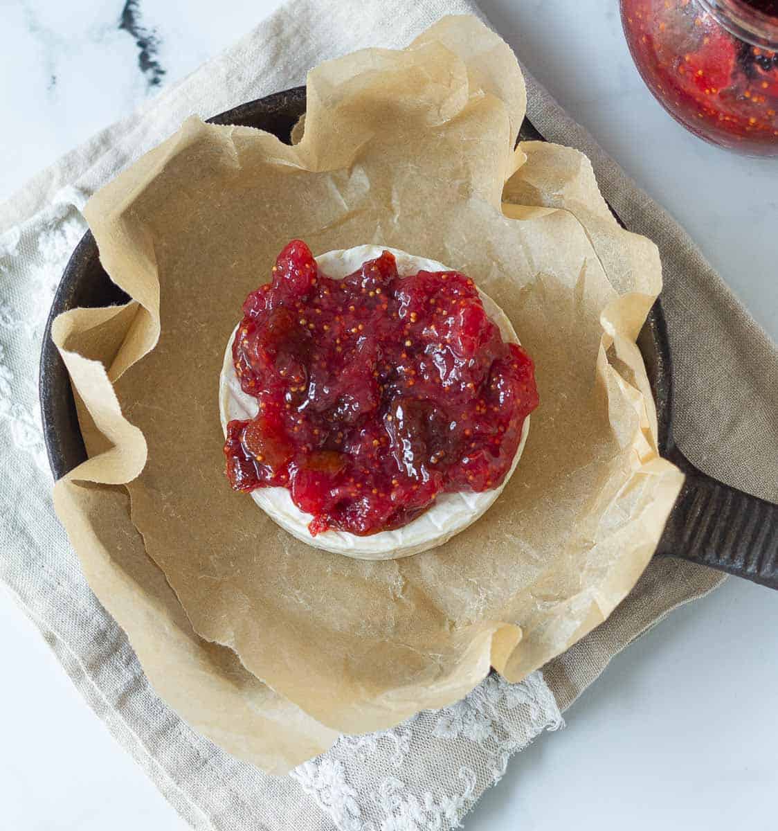 wheel of brie topped with fig jam