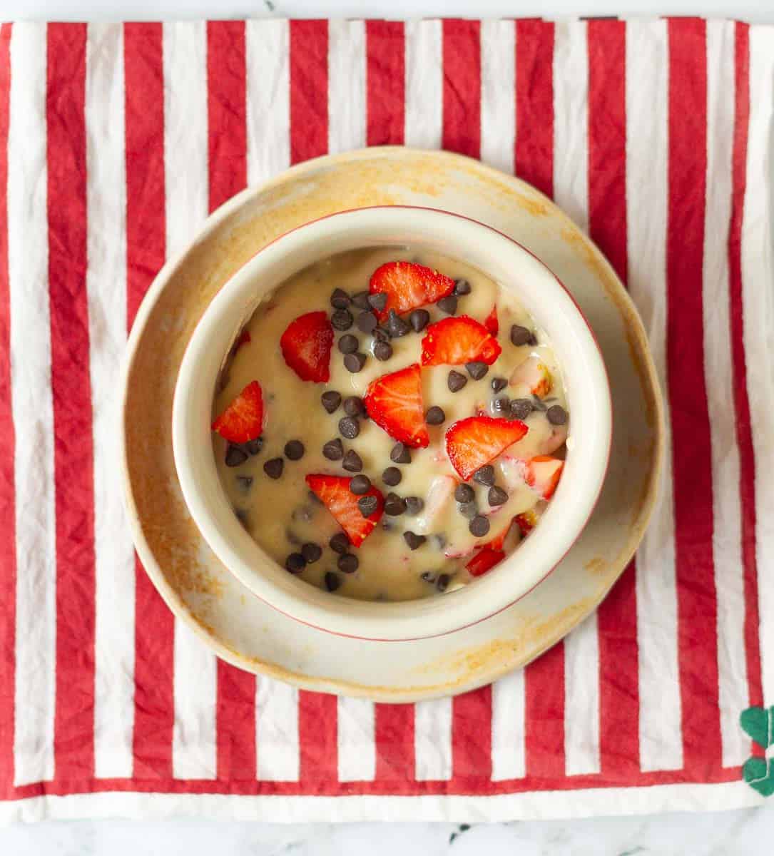 Cake batter in a ramekin on a small plate.