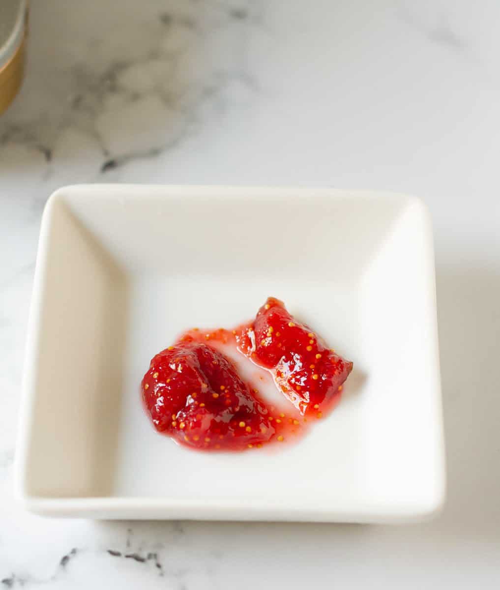 a spoonful of jam on a small white cold plate for testing.