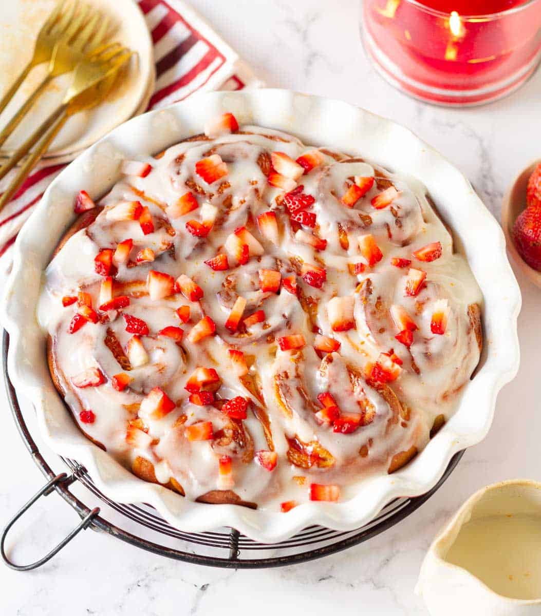 strawberry rolls with cream cheese glaze and garnished with chopped strawberries.