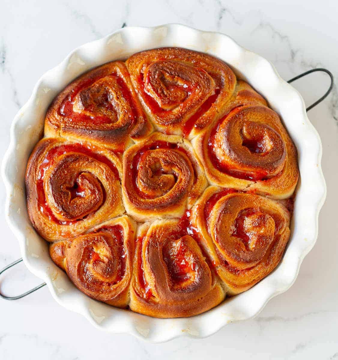 baked strawberry rolls in a round baking dish.